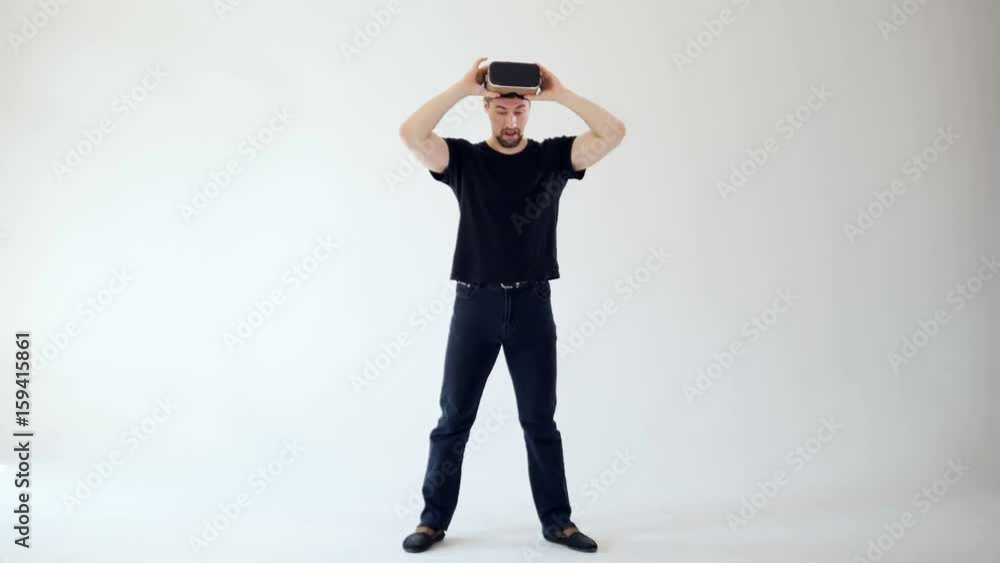 A man taking off virtual reality headset looking amused. A man taking off virtual reality headset looking amused.