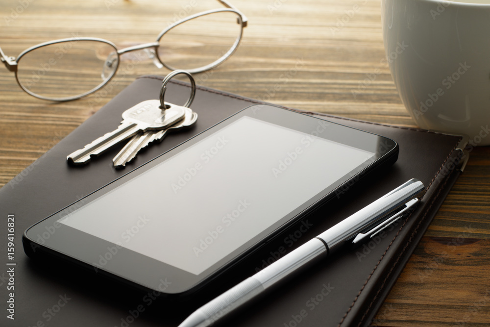 Smartphone and stationery on wood table. Smartphone, pen, keys, glasses, cup and notebook.
Smartphone and stationery on wood table. Smartphone, pen, keys, glasses, cup and notebook.