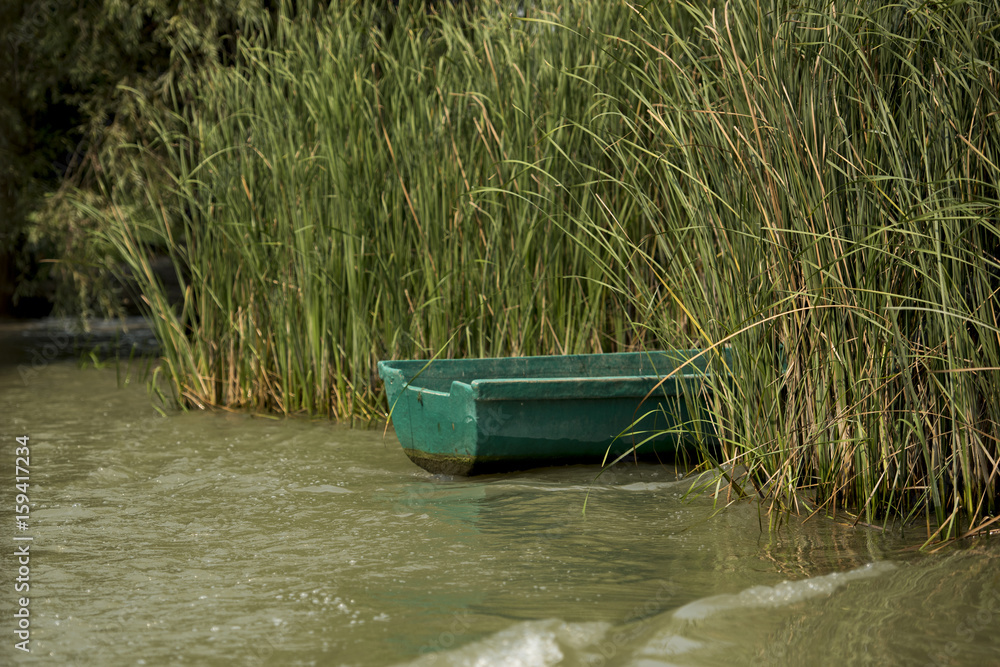 Old boat abandoned in Danube Delta area, Romania, photographed in a sunny summer day Old boat abandoned in Danube Delta area, Romania, photographed in a sunny summer day