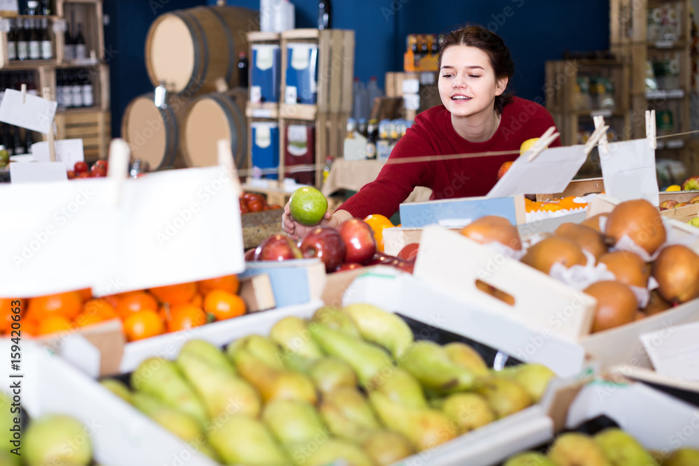 Portrait of  young customer selecting apple in grocery