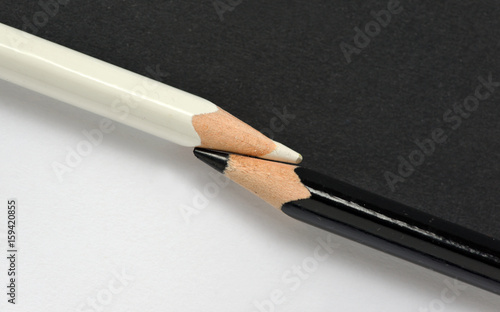 black and white crayons on the same paper background photo