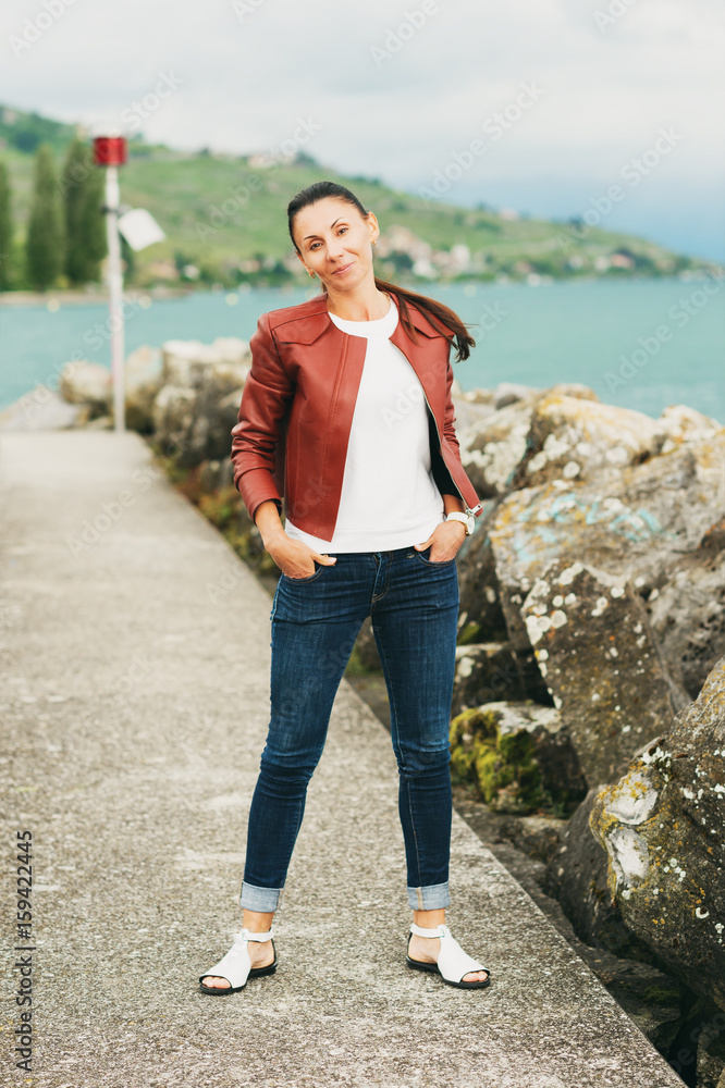 Outdoor portrait of beautiful brunette woman, wearing brown leather jacket Outdoor portrait of beautiful brunette woman, wearing brown leather jacket
