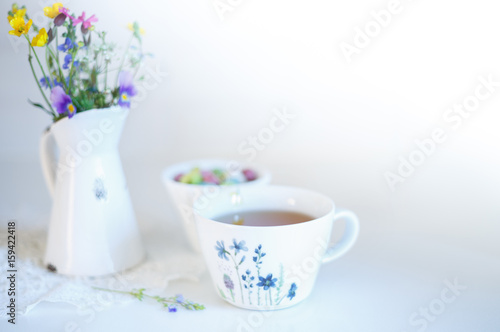 Fototapeta Naklejka Na Ścianę i Meble -  Cup of tea with meadow's flowers in vase