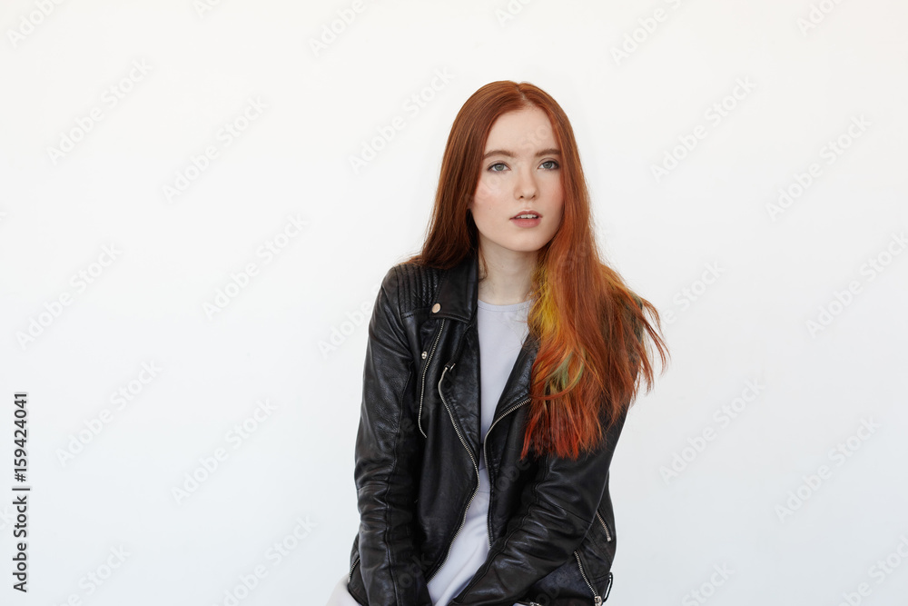 Portrait of the beautiful female model with long red hair and green eyes in  black leather jacket attentively listening to the interlocutor. Hipster  student female resting after lecture in college Stock Photo |
