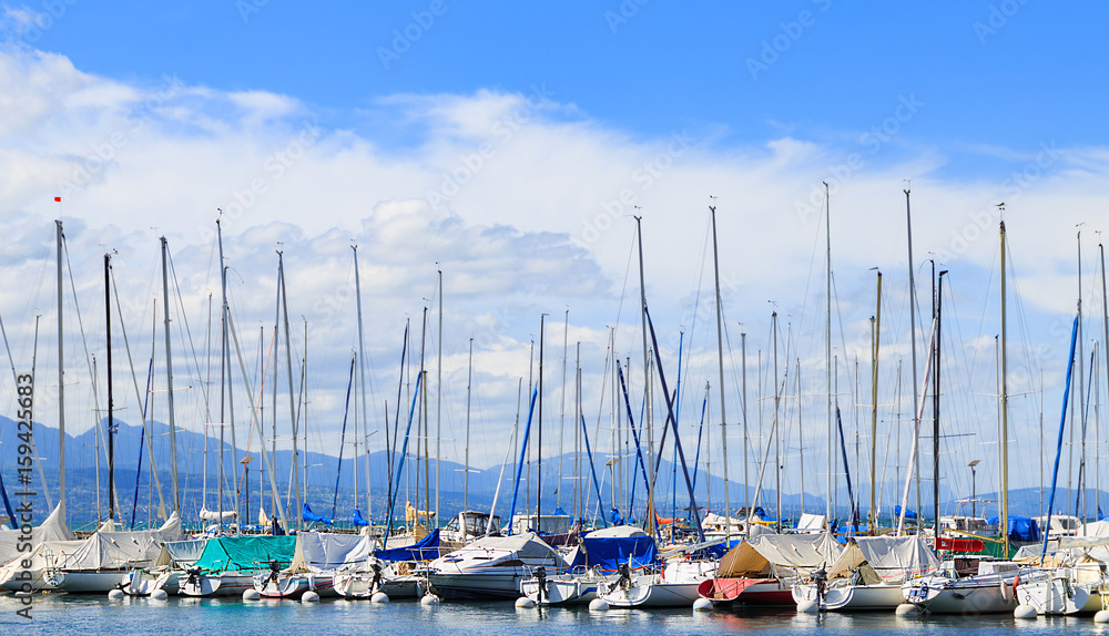 Part of yachts and boats at Ouchy port with the blue spring sky on the background. Lausanne, Switzerland