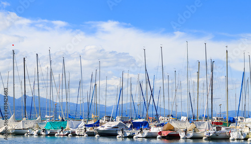 Part of yachts and boats at Ouchy port with the blue spring sky on the background. Lausanne, Switzerland