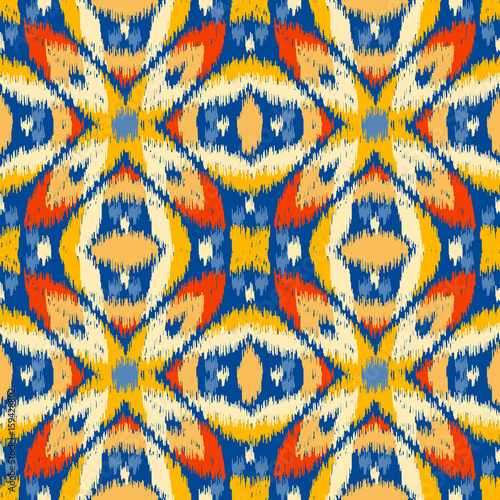 Seamless geometric pattern, based on ikat fabric style. Vector illustration. Carpet rug texture vector imitation. Colorful rug pattern in yellow, red, blue and orange.