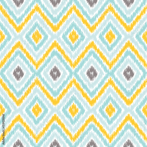 Seamless geometric pattern, based on ikat fabric style. Vector illustration. Carpet rug texture vector imitation. Yellow, turquoise mint and gray chevron pattern.