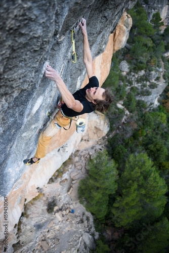 Rock climber ascending a challenging cliff. Extreme sport climbing. Freedom, risk, challenge, success. Sport and active