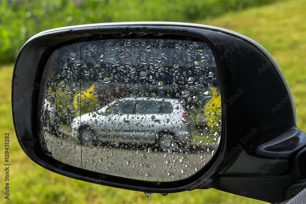 Gray car reflection in a wet rear view mirro Gray car reflection in a wet rear view mirro