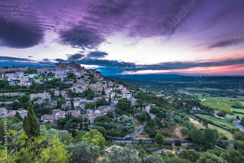 Rising sun over valley with Gordes town