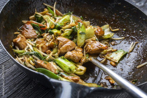 Traditional stir fried Chicken Gung Bao with Vegetable as close-up in Wok.