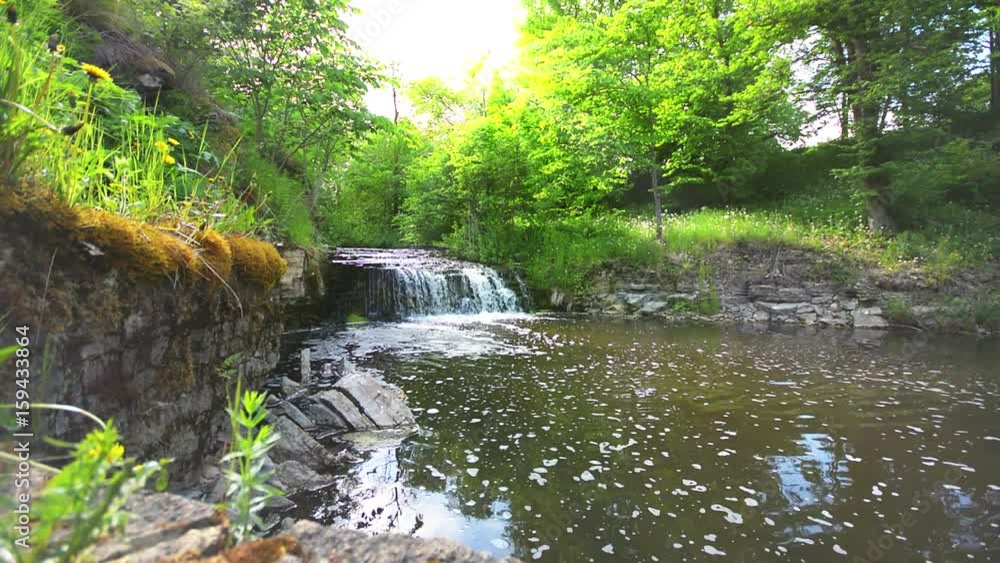 Slider shot of waterfall cascade on river flowing through summer forest. Nature landscape. Slider shot of waterfall cascade on river flowing through summer forest. Nature landscape.