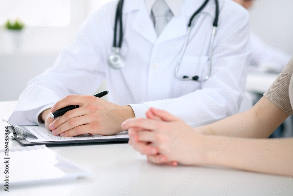 Doctor and patient are discussing something, just hands at the table Doctor and patient are discussing something, just hands at the table