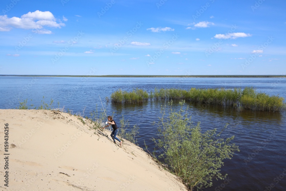 Young girl with a fishing rod on the river bank. Young girl with a fishing rod on the river bank.