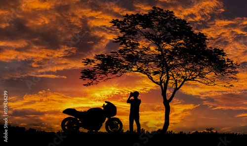 Silhouette, Men Take a photo of the sunset gold color and motorbike Big Bike, beautiful.