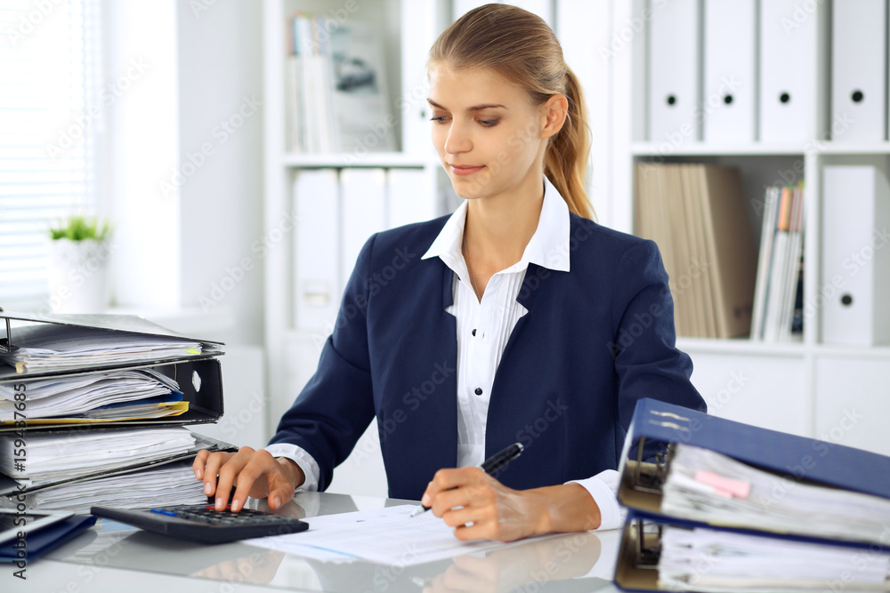 Modern business woman or confident female accountant in office. Student girl during exam preparing. Audit, tax service or education concept Modern business woman or confident female accountant in office. Student girl during exam preparing. Audit, tax service or education concept