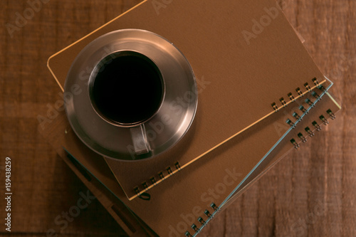 coffee Cup with spoon and biscuits on the background of notebooks
