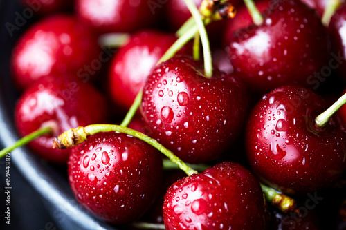 Sweet cherry close-up macro, lies on a plate in droplets of water. Antioxidant, natural, organic berry. Macro background