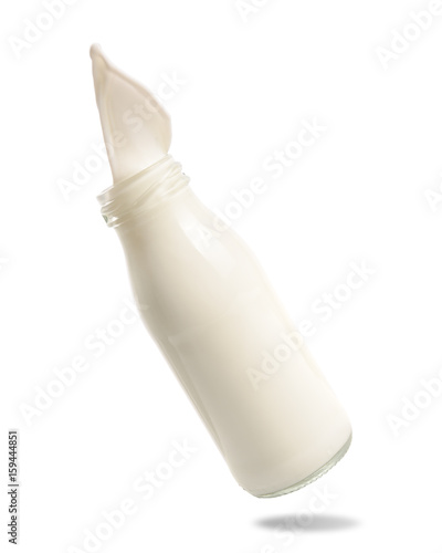 Milk splash out of bottle isolated on white background.