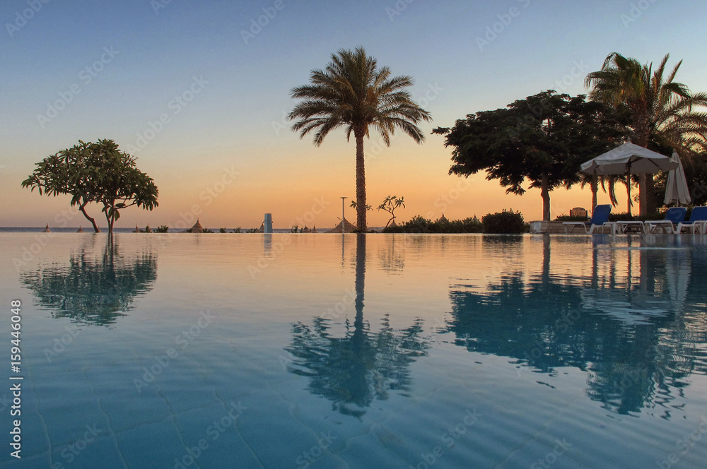 Tropical swimming pool at sunrise