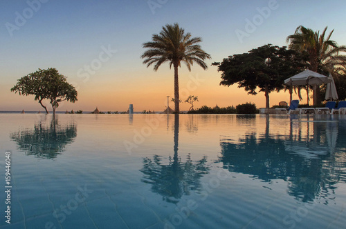 Tropical swimming pool at sunrise