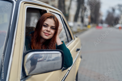 Woman driving, woman peeking out of car window