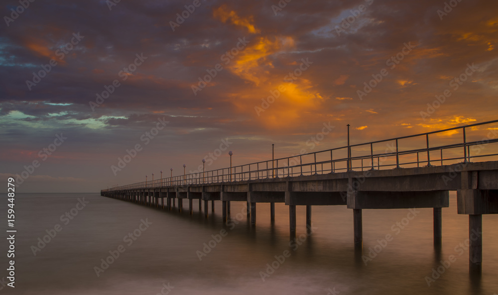Bridge against sun setting clouds