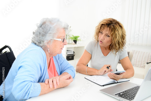 Canvastavla mature woman helping assisted elderly senior female with administrative procedur