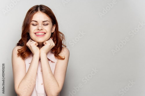 Happy woman with closed eyes on a light background