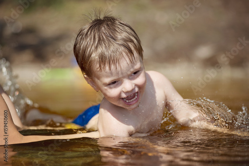 little boy with a smile on my face to learn how to swim in mother s arms