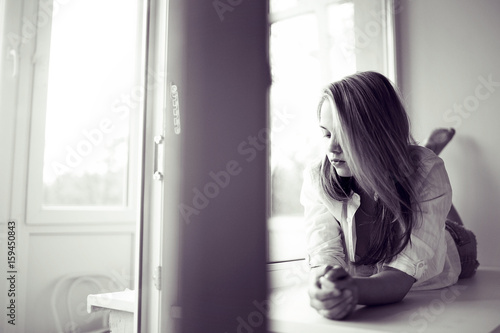 beautiful girl lying at home on a window