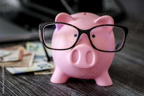 Pink piggy bank with glasses