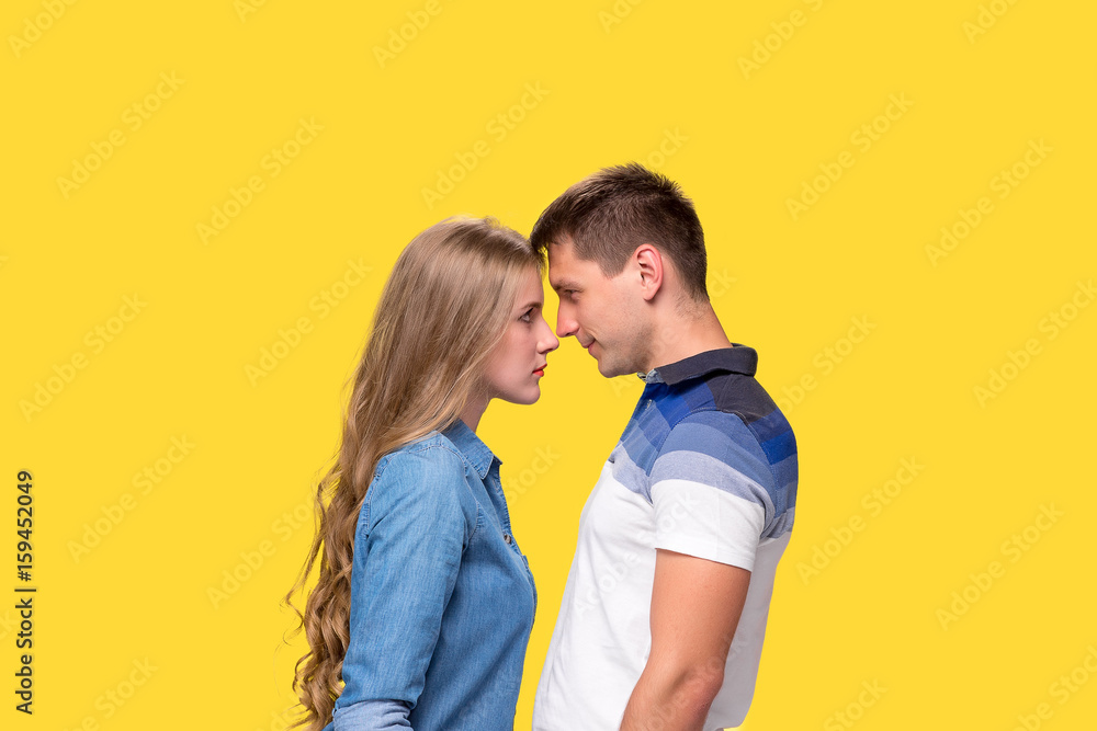 Portrait of a young couple standing against gray background Portrait of a young couple standing against gray background