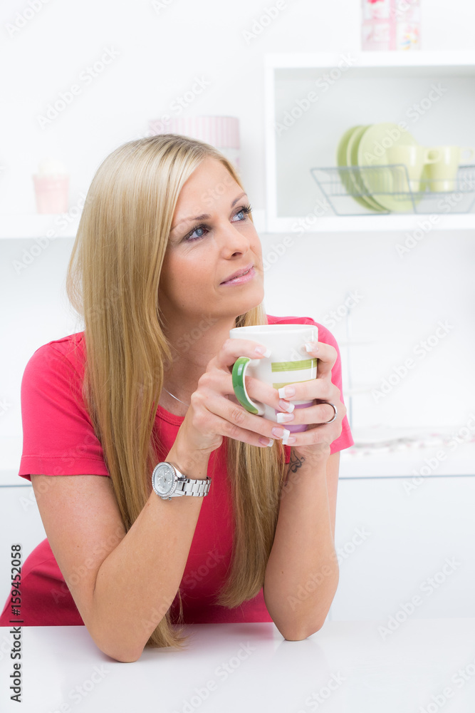 Hübsche Hausfrau in Gedanken an der Küchentheke Hübsche Hausfrau in Gedanken an der Küchentheke