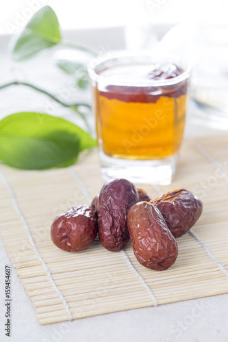 A glass cup of Chinese red date tea on the table. Chinese red dates are believed to be a nutritional supplement that helps promote production of red blood cells.