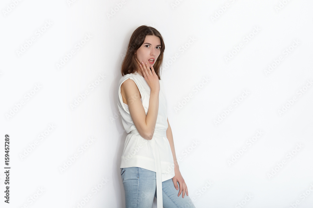 Young beautiful brunette beginner model woman practicing posing showing emotions on white wall studio background Young beautiful brunette beginner model woman practicing posing showing emotions on white wall studio background