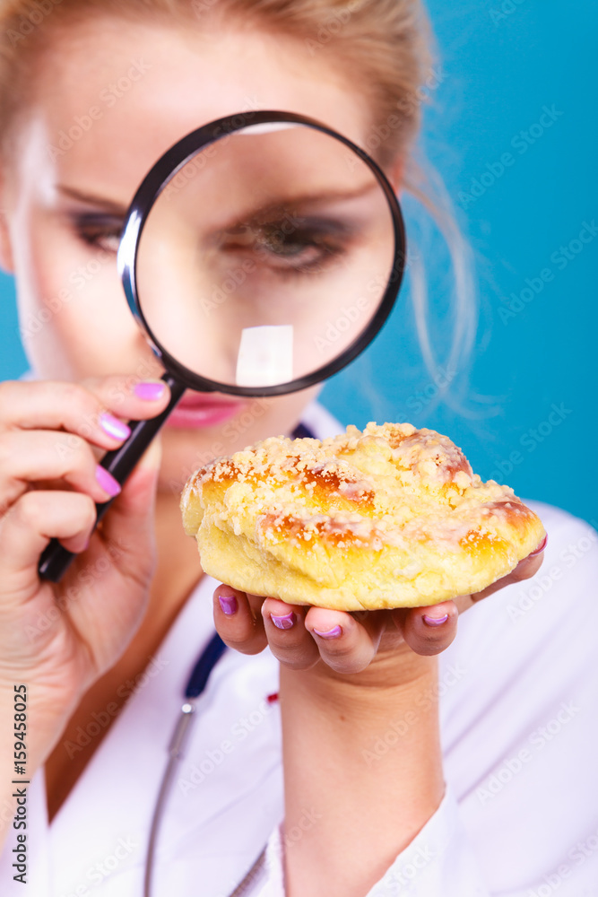Doctor with magnifying glass examining sweet food Doctor with magnifying glass examining sweet food