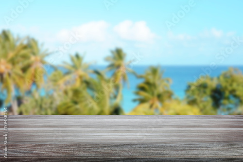 Empty space, wooden table with palm trees and sky in background