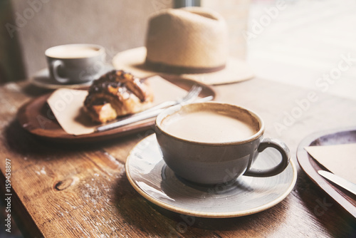 Breakfast, cups of coffee and fresh croissant on a table in a coffee shop photo