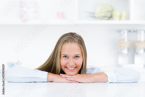 Junge blonde Hausfrau mit Kopf auf der Küchentheke