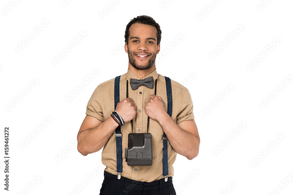 Cheerful stylish young man with instant camera on neck smiling at camera Cheerful stylish young man with instant camera on neck smiling at camera