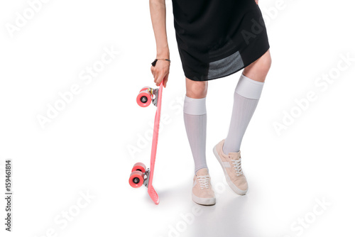 cropped shot of young casual woman holding skateboard isolated on white © LIGHTFIELD STUDIOS