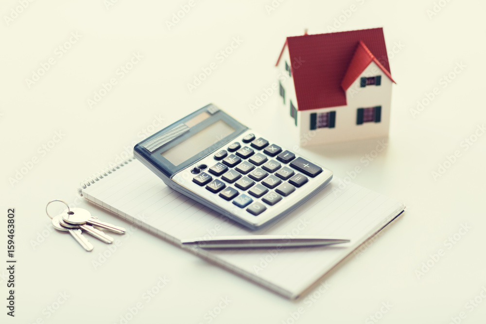 close up of home model, calculator and notebook close up of home model, calculator and notebook