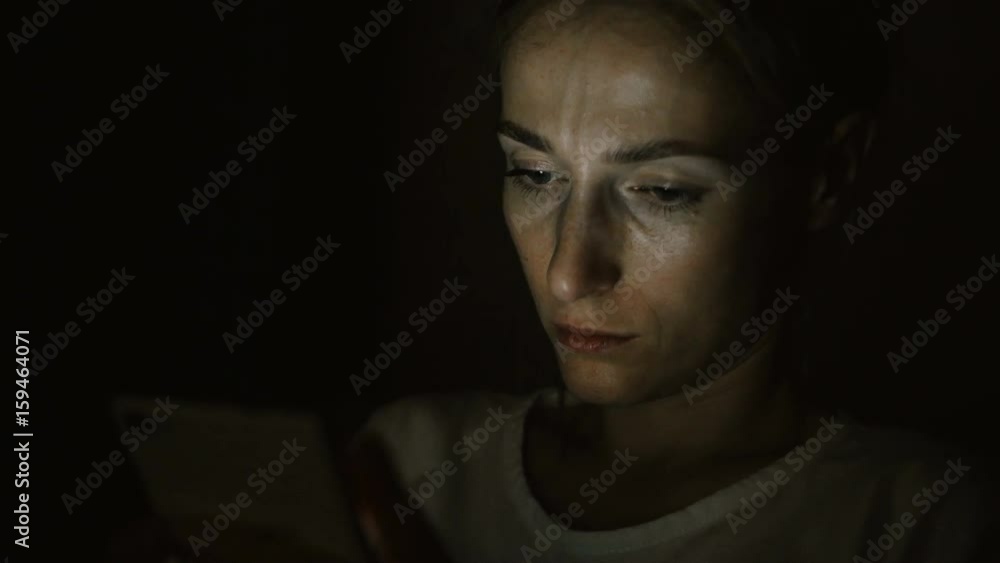 Tired sad woman using cellphone at night. Tired sad woman using cellphone at night.