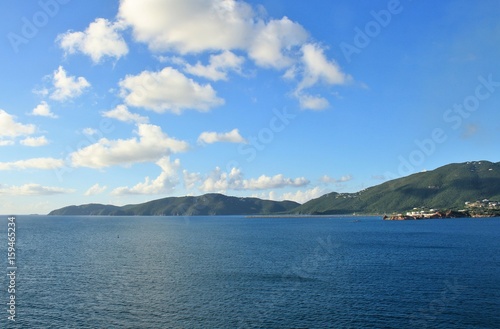 Ocean and mountain landscape with blue sky and white clouds