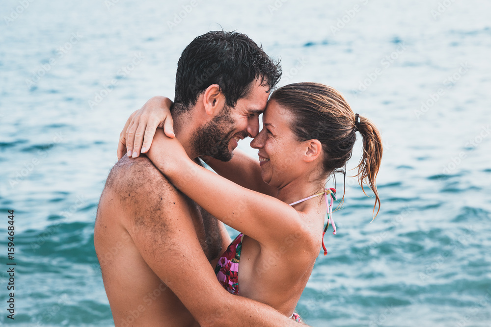 Young couple in love hugging at the beach