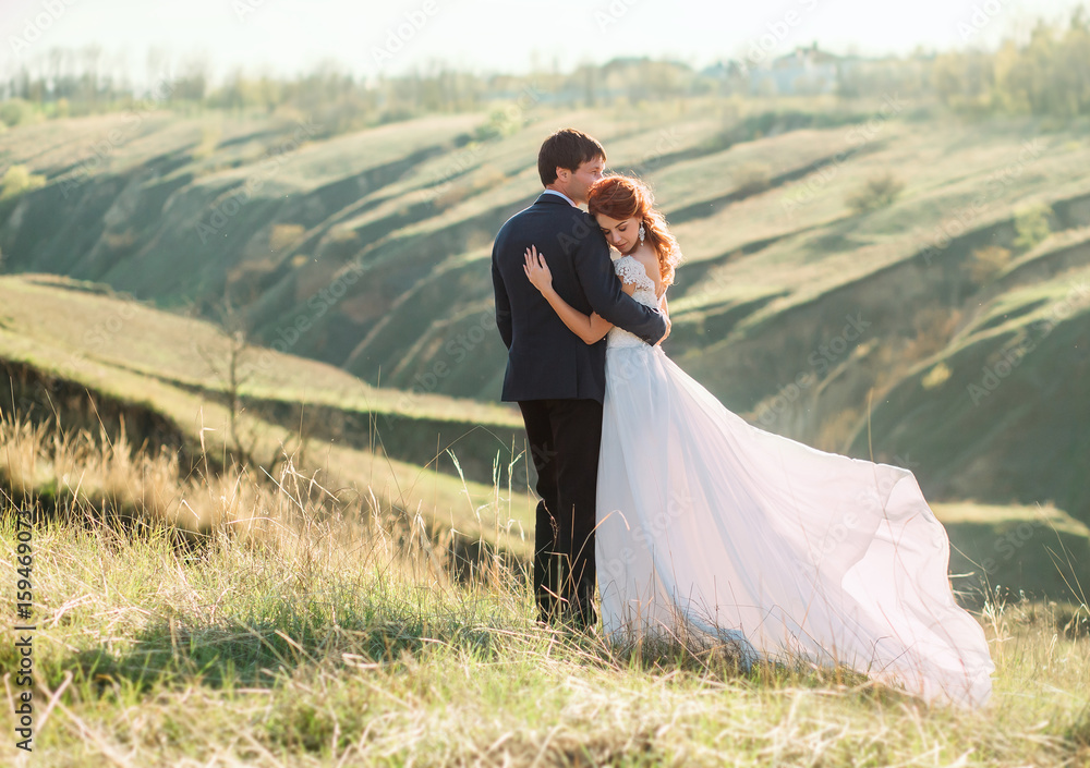 Stylish wedding on a nature. Walk of lovers at sunset. A beautiful love story. Film colors.
