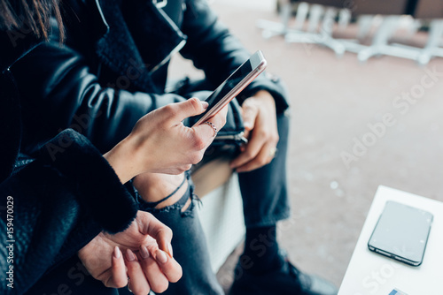 Close up hands of young couple using smart phone - technology, social network, communication concept