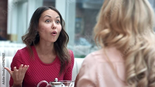 Two young women argue in cafe